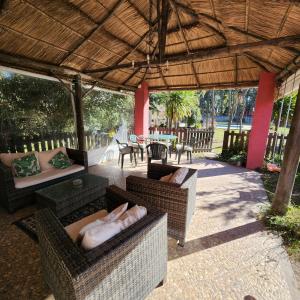un patio al aire libre con muebles de mimbre y techo de madera. en Hotel y Casa de Campo Oasis Campero Ezeiza -San Vicente en San Vicente