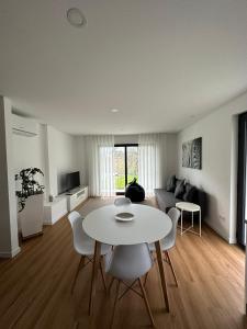 米尼奧河畔維埃拉的住宿－Ri&Vale Alojamentos，客厅配有白色的桌子和椅子
