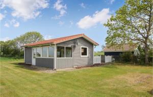 una pequeña casa gris con un gran patio en Gorgeous Home In Sams With Kitchen en Kolby Kås