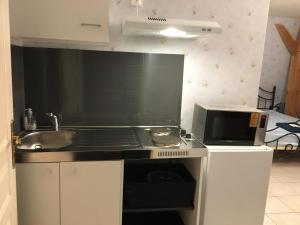 a small kitchen with a sink and a microwave at Orchidee Rose in Givet
