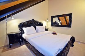 Bett in einem Zimmer mit einem Spiegel und einem Bett sidx sidx sidx sidx in der Unterkunft Villa Troya in Safed