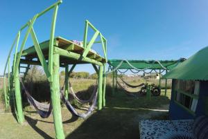 a swing set with hammocks in a park at Green House Hostel in Cabo Polonio