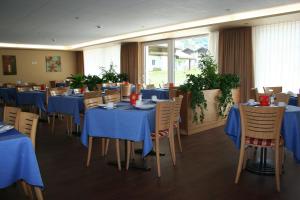 ein Esszimmer mit Tischen und Stühlen mit blauem Tischtuch in der Unterkunft Welcome Hotel Täsch by Täscherhof in Täsch