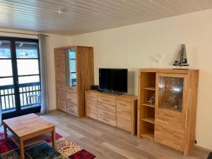 ein Wohnzimmer mit einem TV und einem Entertainment-Center in der Unterkunft Ferienwohnung am Walchensee in Walchensee