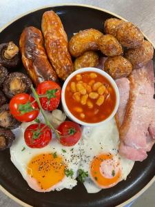 a plate of breakfast food with eggs sausage and beans at Furzeleigh Mill in Buckfastleigh