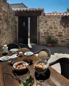 un tavolo in legno con ciotole di cibo sopra di Casa Rural El Caldero a Sorihuela