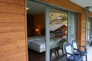Camera dotata di balcone con letto e sedie. di Welcome Hotel Täsch by Täscherhof a Täsch
