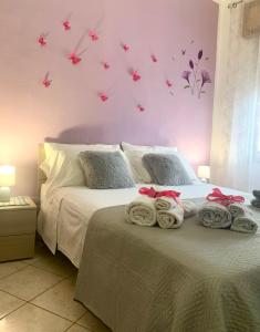 - une chambre dotée d'un lit avec des serviettes et des papillons sur le mur dans l'établissement Butterfly House, à Villaputzu