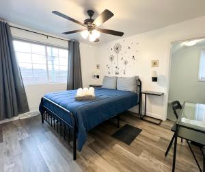 a bedroom with a blue bed and a ceiling fan at Sunny Queen bedroom feel like home!! in Englewood
