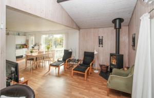 sala de estar con chimenea, mesa y sillas en Beautiful Home In Sams With Kitchen en Kolby Kås