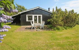 a black cottage with a table and chairs in the yard at Beautiful Home In Sams With Kitchen in Kolby Kås