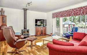 uma sala de estar com mobiliário vermelho e uma lareira em Amazing Home In Henn With Kitchen em Henån