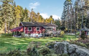 uma casa vermelha no meio de uma floresta em Amazing Home In Henn With Kitchen em Henån