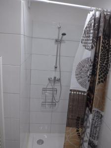 a shower in a bathroom with a shower curtain at Duplex sur un fameux Grain de sable in Bonifacio