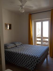 a bedroom with a bed and a sliding glass door at Duplex sur un fameux Grain de sable in Bonifacio