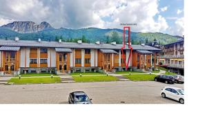 a large building with cars parked in front of it at Viva Maria Apartamenty in Zakopane