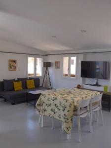 een woonkamer met een tafel en een bank bij Duplex sur un fameux Grain de sable in Bonifacio