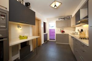 a kitchen with gray cabinets and a purple door at Haus Alpenflora in Längenfeld