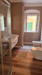 łazienka z umywalką, toaletą i oknem w obiekcie Enjoy Home w Genui