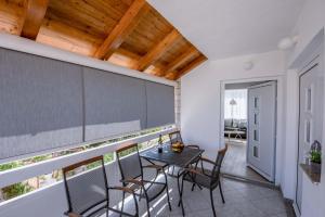 uma sala de jantar com uma mesa e cadeiras numa varanda em Apartments Una em Poljica
