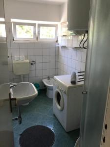 ein Badezimmer mit einer Waschmaschine und einem Waschbecken in der Unterkunft Maestral in Rovinj