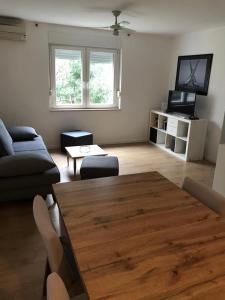 sala de estar con mesa de madera y sofá en Maestral, en Rovinj
