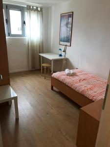 Schlafzimmer mit einem Bett, einem Schreibtisch und einem Fenster in der Unterkunft Maestral in Rovinj
