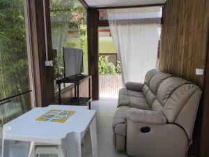 a living room with a couch and a table at Chalé do Tibet Vale da Utopia Praia de Cima in Pinheiro