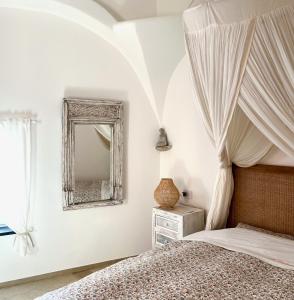 1 dormitorio con cama con dosel y espejo en Al Bastione del Borgo Saraceno, Varigotti, en Varigotti