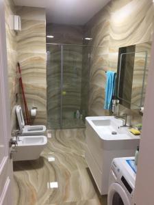 發羅拉的住宿－LUX SEAVIEW APARTMENT，一间带水槽、淋浴和卫生间的浴室