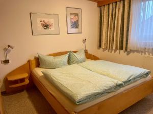 a small bedroom with a bed with a window at Ferienwohnung Martha in Obsteig