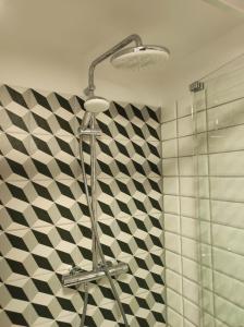 un bagno con doccia e piastrelle bianche e nere di Apartament AirPort a Breslavia