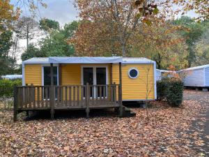 żółty domek z werandą i tarasem w obiekcie Camping 5* - Biscarosse Lac - MobilHome 2 chambres - 4 personnes w mieście Biscarrosse