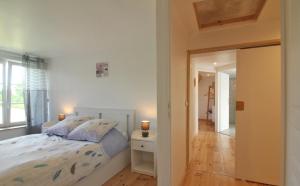 um quarto com uma cama e uma porta que leva a um corredor em La Meunière 2 em Montmerrei