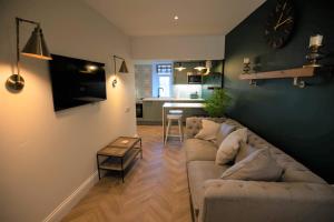 a living room with a couch and a table at Ridley's Place modern one-bedroom seaside apartment in Eyemouth
