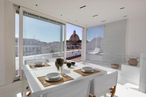 a white dining room with a view of the city at WeLive Trapani - luxury apartments in Trapani