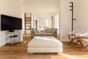 ein Wohnzimmer mit einem Sofa und einem Flachbild-TV in der Unterkunft WeLive Trapani - luxury apartments in Trapani