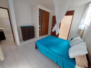 聖弗朗西斯的住宿－Appartement F5 dans maison à Saint François，一间带蓝色床的卧室和一间浴室
