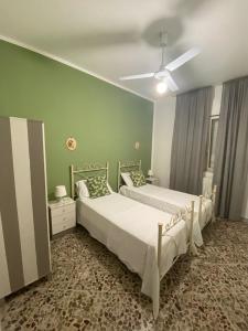 two beds in a bedroom with green walls at Alloggio Ugo Foscolo in Monopoli