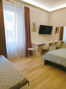 a hotel room with a bed and a desk with a television at Casa Brenta in Cosenza