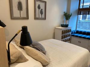 a bedroom with a bed with a lamp on it at Ridley's Place modern one-bedroom seaside apartment in Eyemouth