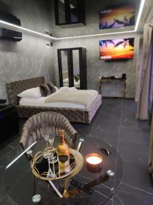 Pensjonat Wrzos في بوزنان: غرفة مع سرير وطاولة مع زجاجة من النبيذ