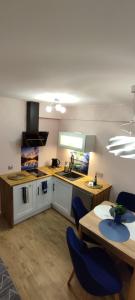 a kitchen with a table and two chairs and a counter at Apartament Nad Zalewem Zegrzyńskim in Serock