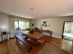 a living room with a wooden table and a large window at Lagoon View in Plettenberg Bay
