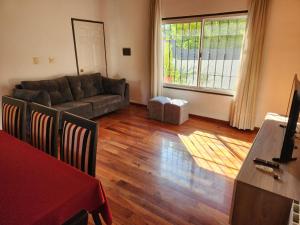 a living room with a couch and a table at Casa DELUXE MALBEC , Barrio Privado, con cochera doble, jardín y churrasquera in Mendoza