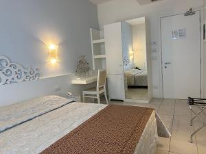 a bedroom with a bed and a desk and a desk at Hotel Albatros in Lido di Jesolo