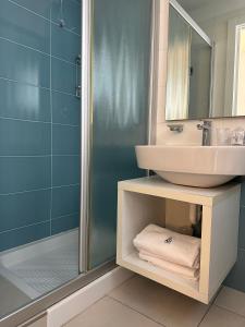 uma casa de banho com um lavatório e um chuveiro em Hotel Albatros em Lido di Jesolo