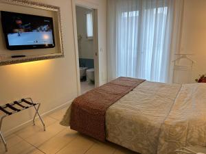- une chambre avec un lit et une télévision murale dans l'établissement Hotel Albatros, à Lido di Jesolo