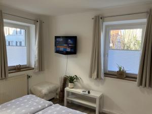 1 Schlafzimmer mit 2 Betten und einem TV an der Wand in der Unterkunft Metter in Bietigheim-Bissingen