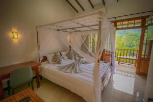 a bedroom with a white bed with a canopy at MOUNT PLEASANT ELLA in Ella